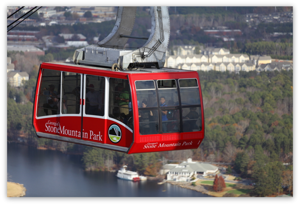 Stone Mountain Park, Dec 03, 2012 - The red Summit Skyride/Skylift car ascends to the top of Stone Mountain while the passenger in the front eyes me taking her photo